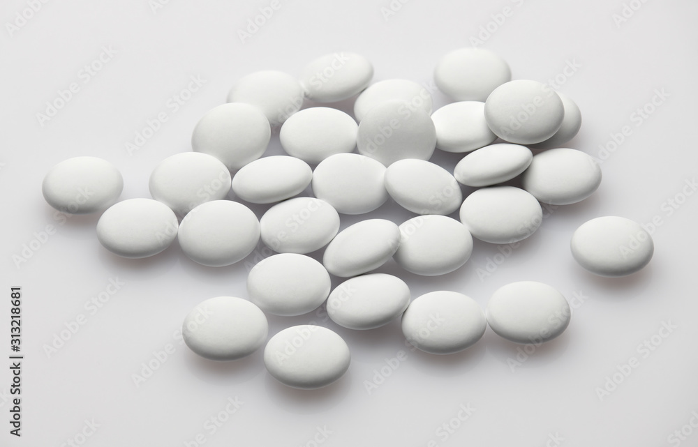 Group of white pills on white background - healthcare and medicament concept. Pharmaceutical industry. Pharmacy. Group of white pills on white background - healthcare and medicament concept. Pharmaceutical industry. Pharmacy.