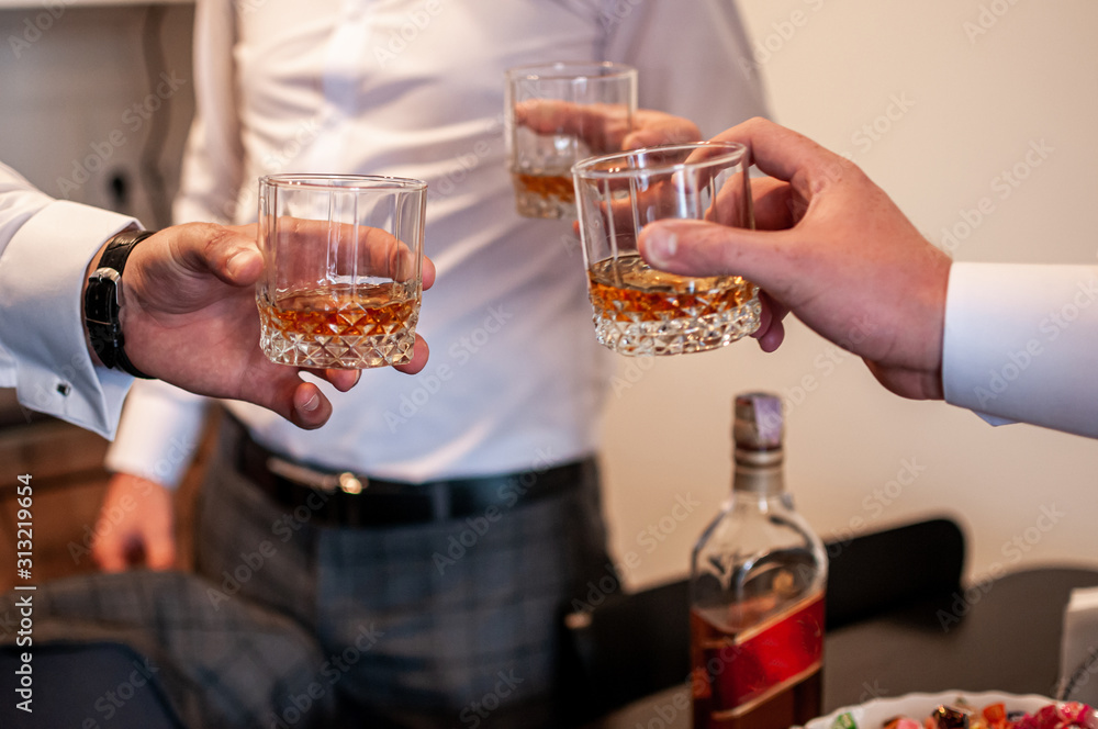 Mans clink glasses with whisky Mans clink glasses with whisky