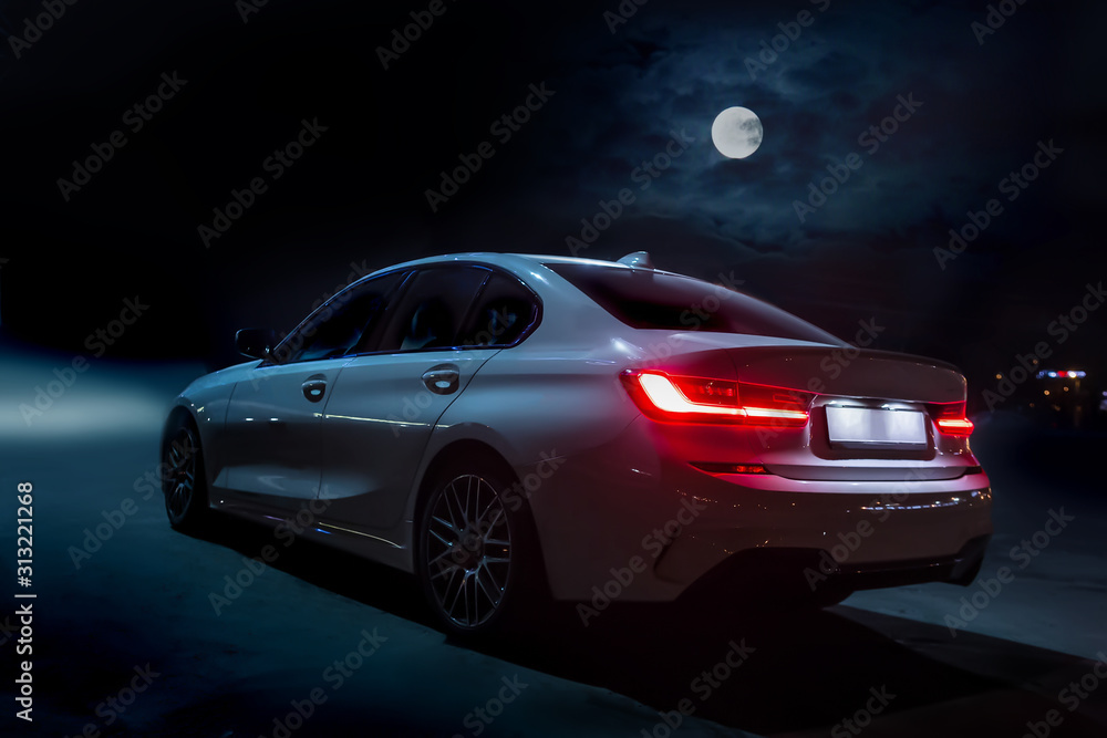 Fototapeta premium Car moves on the road on a moonlit night.