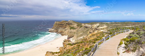 Panorama of Dias Beach with wooden walkway leading through fynbos vegetation with view to the ocean on a sunny day, Cape of Good Hope, South Africa
