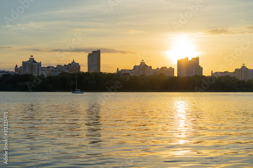 River beach at the sunset with cityscape at the background