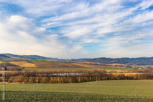 Evening sky over hilly landscape, meadows and forests in Czech Republic, Central Europe.