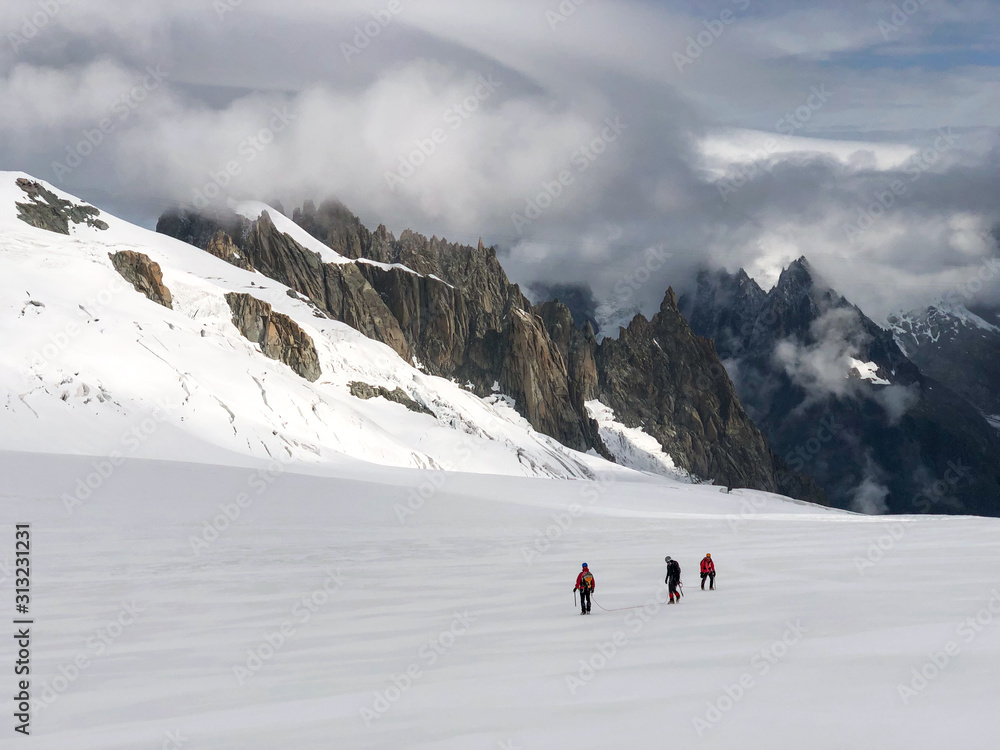 Alpinists walking on the Glacier Blanc, near the Aiguille du Midi in the French Alps