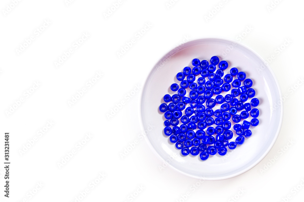 Fototapeta .Round blue beads for making jewelry shot large on a white background