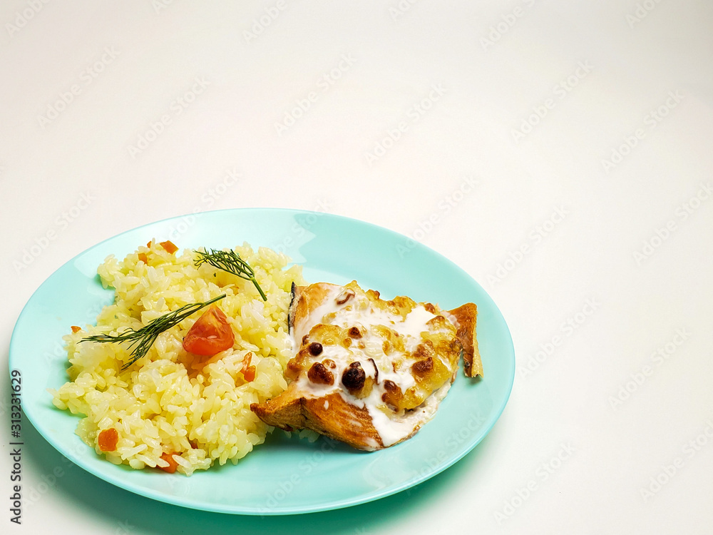 Fried fish steak with white rice on a plate on a white background. fish fillet with rice