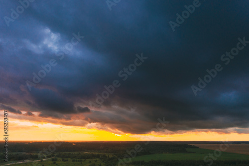 Aerial View Of Sunset Sky Above Green Forest Landscape In Evening. Top View From High Attitude In Summer Sunrise. Rain Clouds