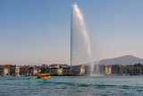 The Geneva Water Fountain, Jet d.Eau, in the city of Geneva. One of the for Geneva typical yellow boats.