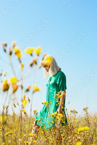 Woman walking in summer field with flowers photo