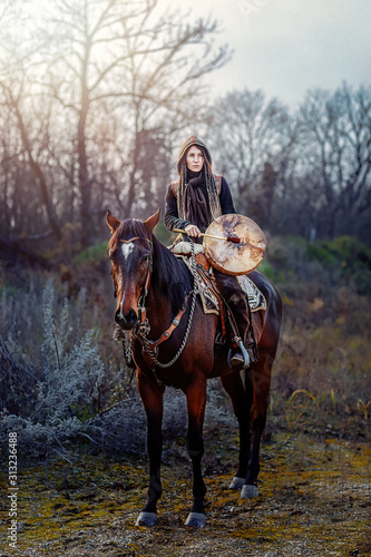 young dreadded girl with her horse and shamanic frame drum.