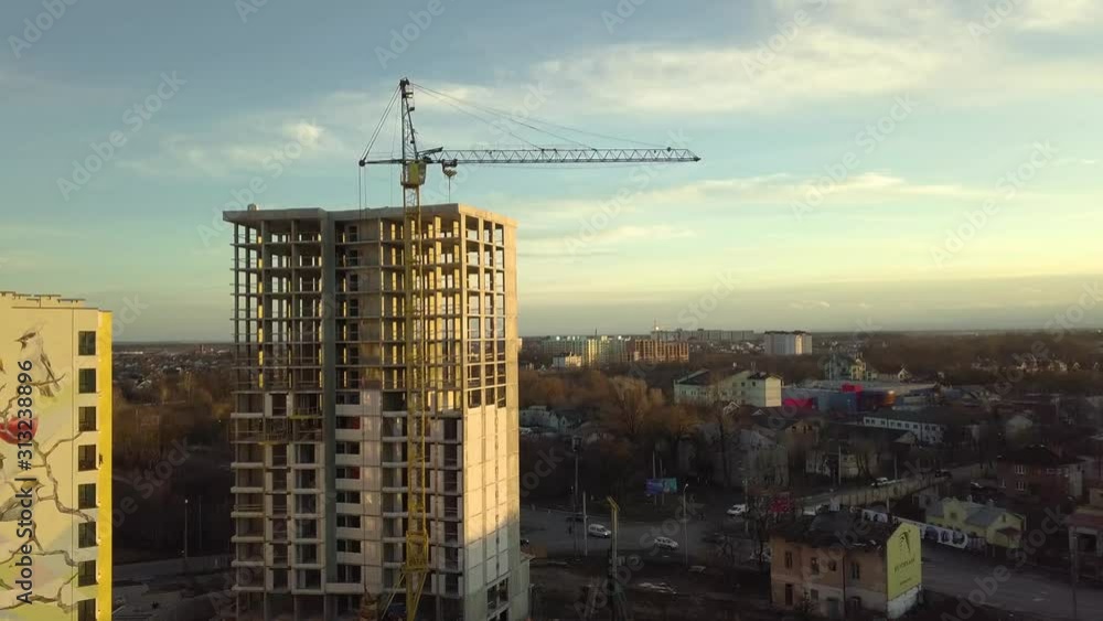 Aerial view of concrete frame of tall unfinished apartment building under construction in a city. Aerial view of concrete frame of tall unfinished apartment building under construction in a city.