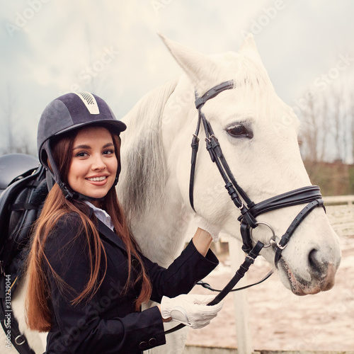 Vintage fashion portrait of beautiful jockey woman and white horse