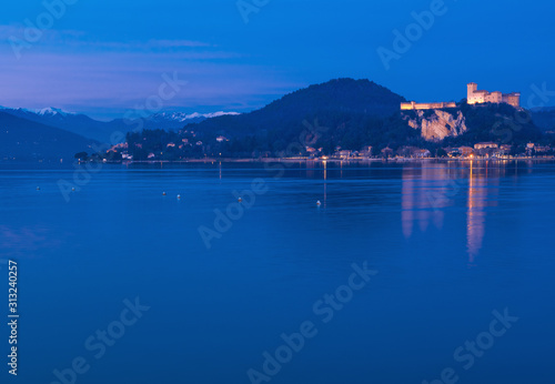 framed by the snow-capped Prealps, the Angera fortress dominates Lake Maggiore in the blue hour