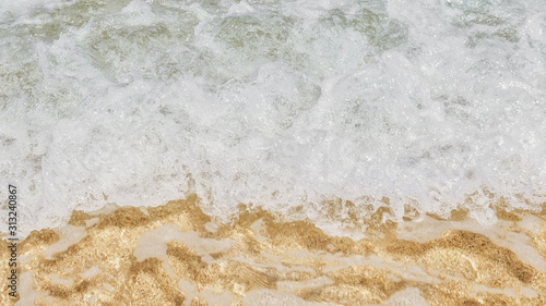 Ocean waves and sand. View from above. Travel background