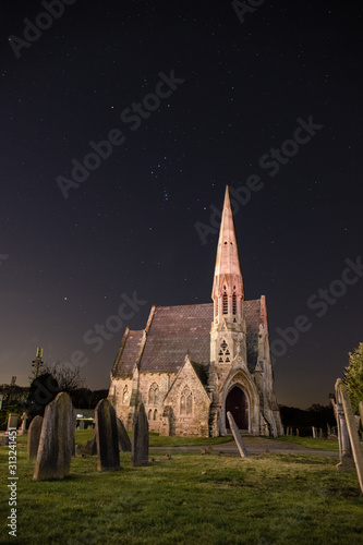 Orion crossing over an old church at night