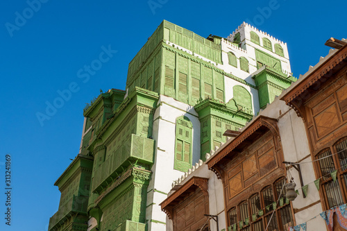 View of the famous greenish Noorwali coral town house at the Souk al Alawi Street in the historic city center of Al Balad, Jeddah, Saudi Arabia photo