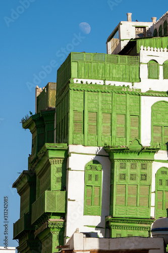 View of the famous greenish Noorwali coral town house at the Souk al Alawi Street in the historic city center of Al Balad, Jeddah, Saudi Arabia photo