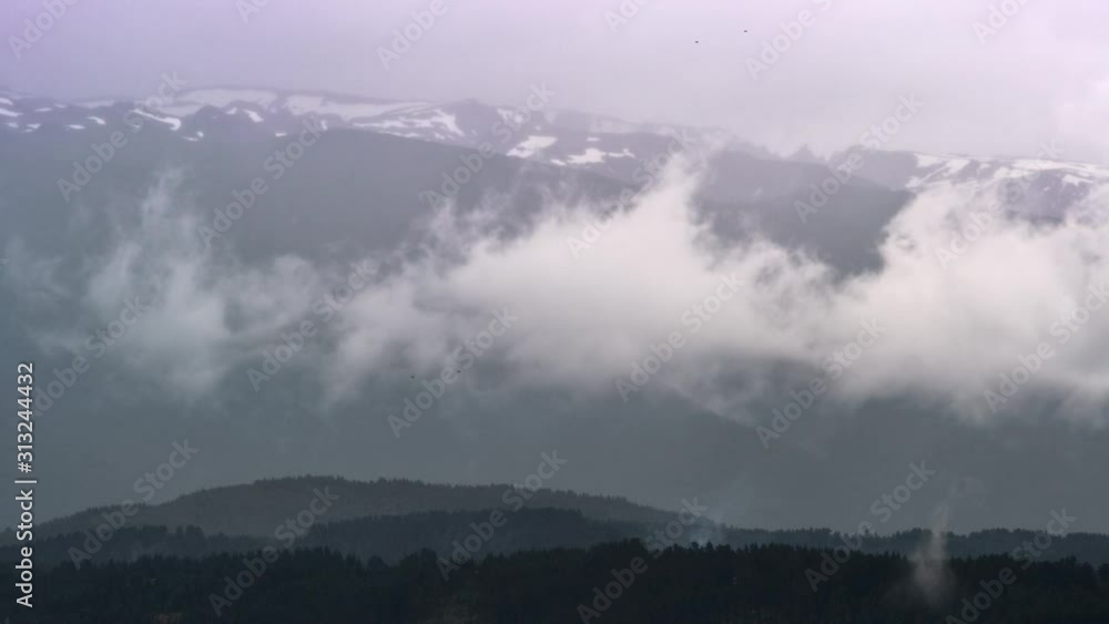 Timelapse of Thin White Clouds with a Mountain Forest Range in Background Timelapse of Thin White Clouds with a Mountain Forest Range in Background
