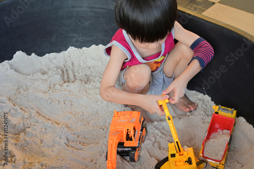 Fotografie, Obraz child boy play construction vehicle toy in sand playground
