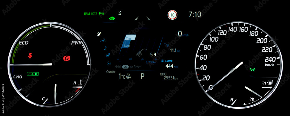 Average fuel economy consumption display between circular speedometer and power monitor. Illuminated car instrument panel with display fuel range, fuel and temperature gauge, odometer in hybrid car.