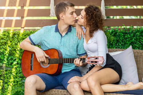 Couple Caucasian playing acoustic guitar for his beloved girl.