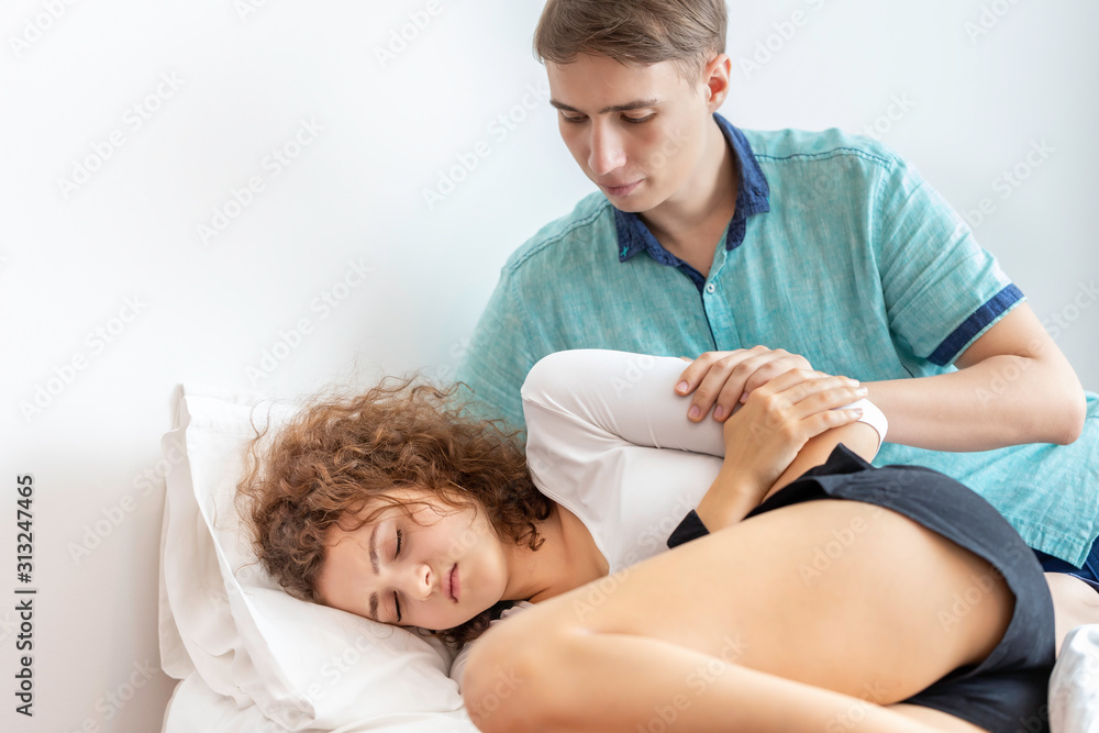 Boyfriend take care girlfriend.Young Caucasian woman patient with period  pain on bed room. Stock-foto | Adobe Stock