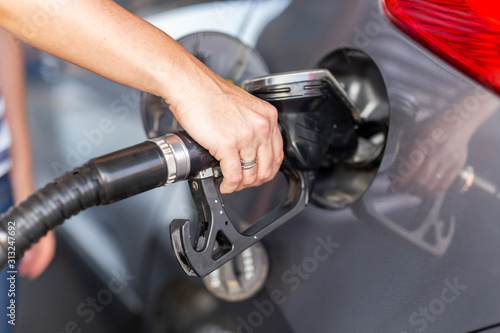 Woman refueling car at petrol station