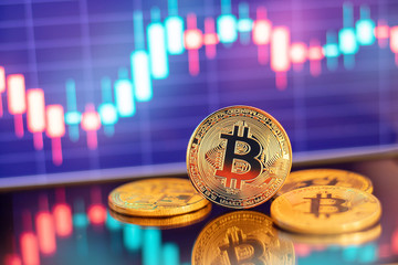 Gold Bitcoin crypto currency on background of chart diagram