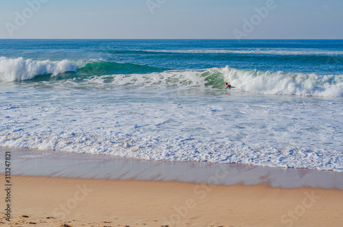 Picturesque beach in Portugal  ocean waves run ashore. Good weather for surfing.