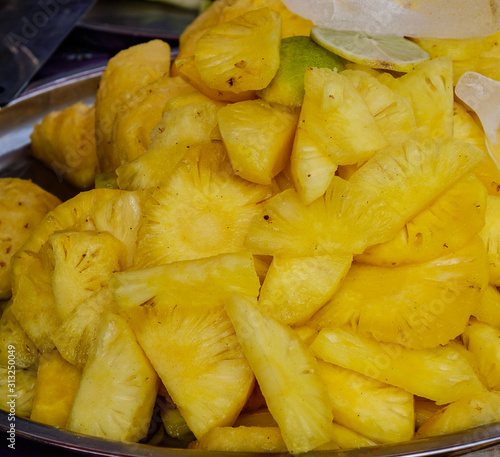 Cutting pineapple fruits for sale at street market