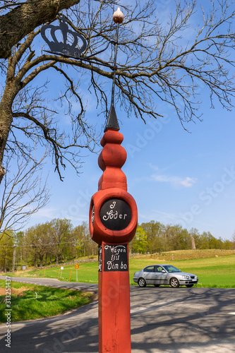 Old signpost at a crossroads in Sweden with a car photo