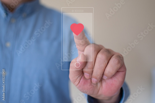 Transparent smartphone with the heart symbol instagram style, young man hiting like button on social media
