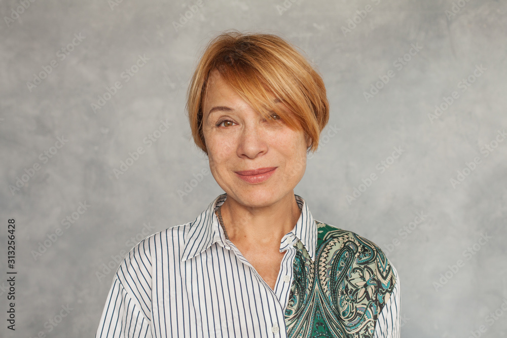 Beautiful mature woman face on gray background Beautiful mature woman face on gray background