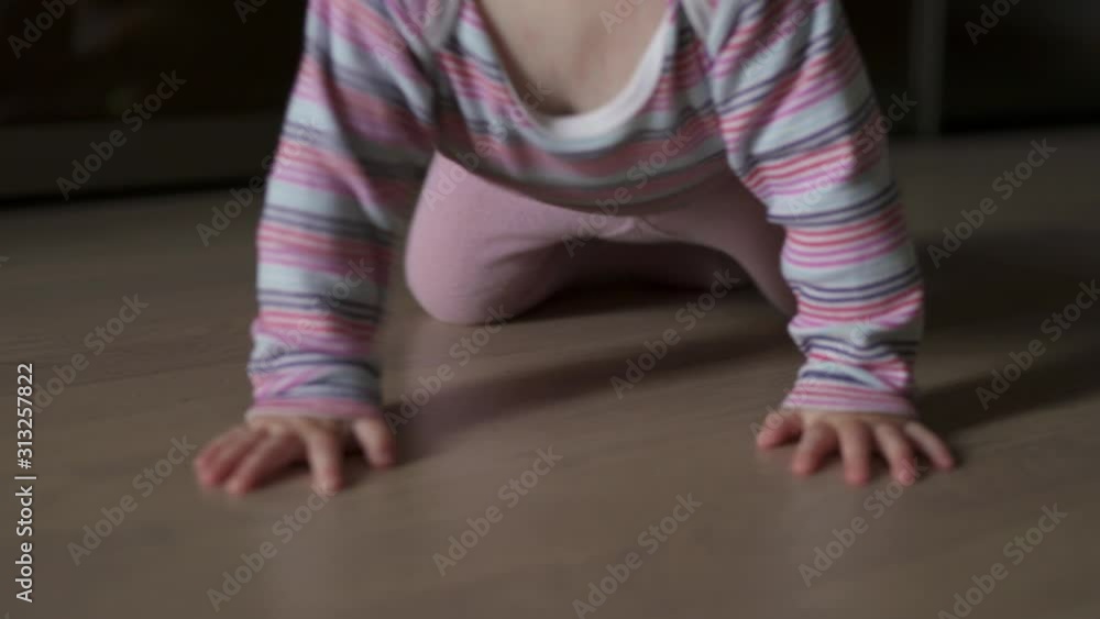 A young child learns to crawl on the floor. A young child learns to crawl on the floor.
