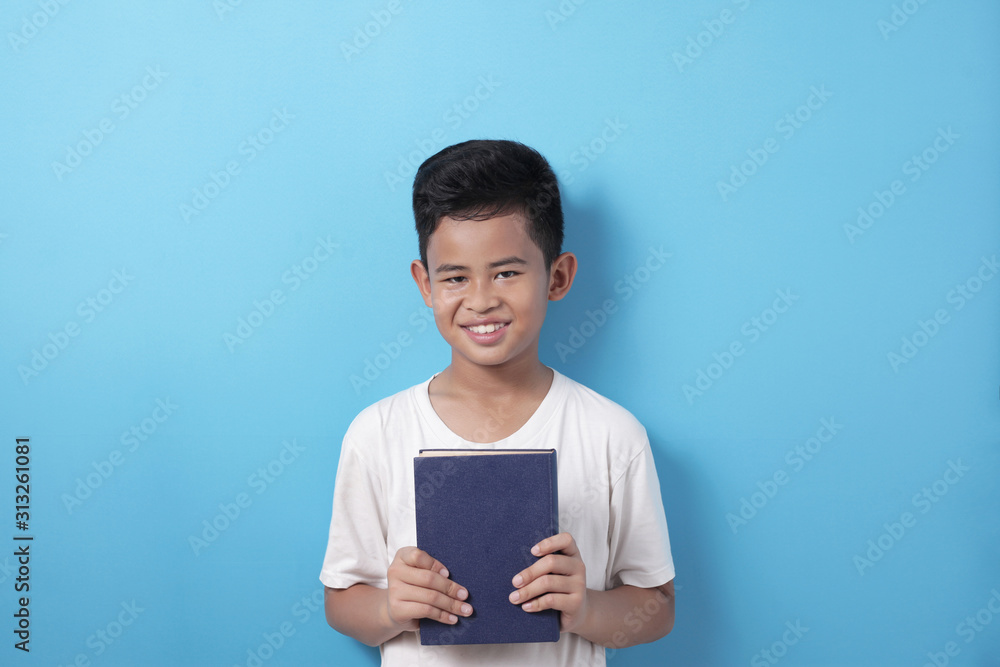 Asian student boy holding book and smile to camera, educational and knowledge concept Asian student boy holding book and smile to camera, educational and knowledge concept