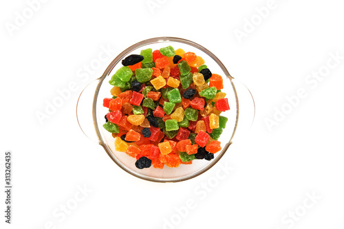 Assorted candied fruits in a glass dish on a white background