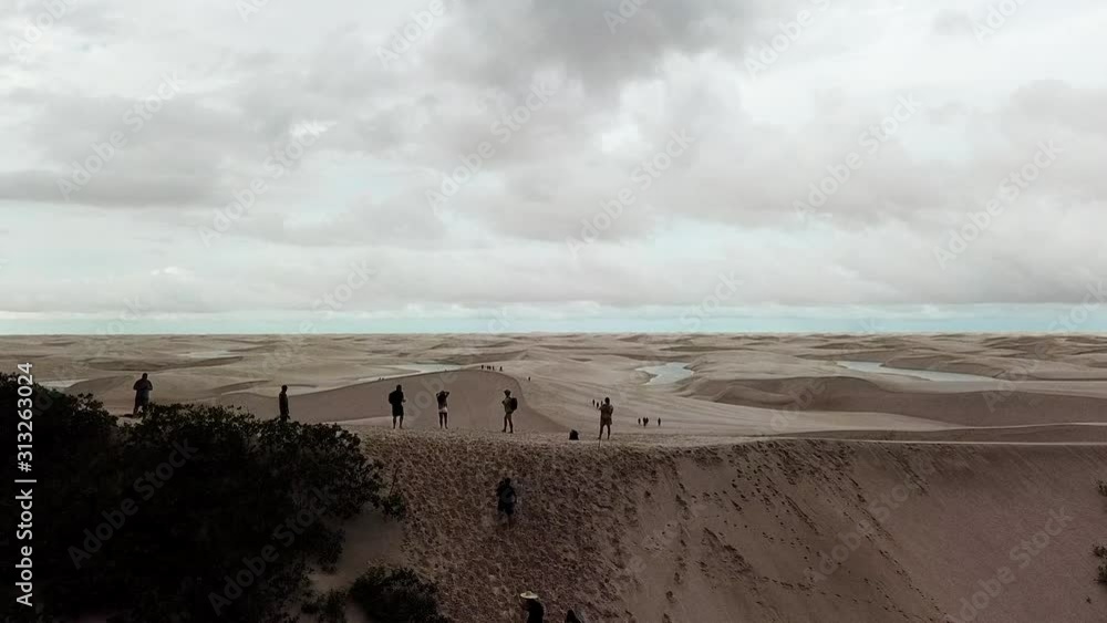 Refugees begin crossing an exanpsive desert landscape. Aerial reveal shot, boom up. Refugees begin crossing an exanpsive desert landscape. Aerial reveal shot, boom up.