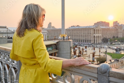 Back view of woman looking at panorama of city sunset