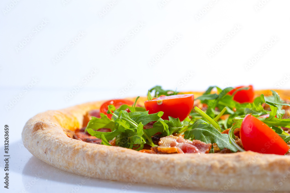 Italian hot pizza with tomato, arugula and pieces of bасon isolated on white background