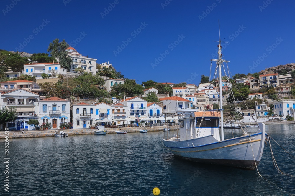 cozy port of the picturesque coastal town Evdilos with traditional fishing boat on the authentic Greek Island of Ikaria