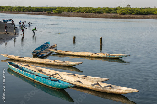 Fishers and small long boats. Fadiauth Island. Senegal. West Africa.