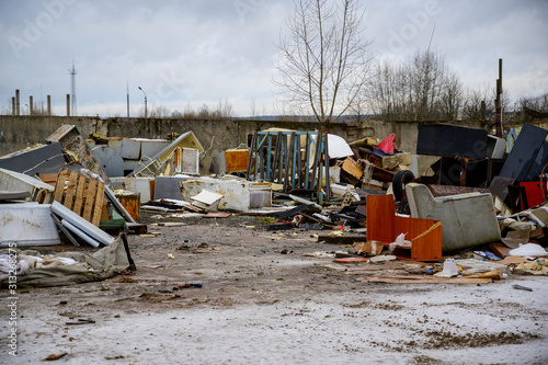 The concept of trash environmental disaster. Photo of a landfill on a street in a city on a cloudy day.