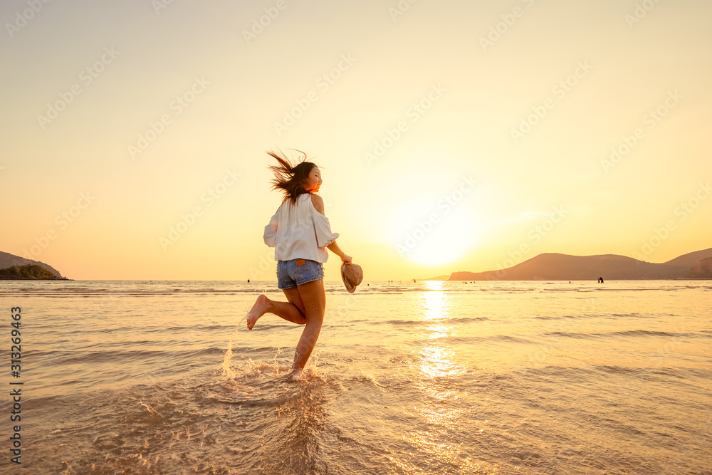 A woman running in to the beach. Woman happy with vacation summer on the beach and sunset.