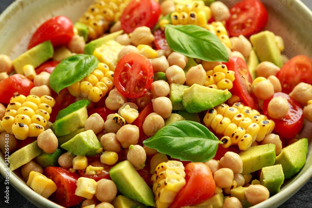 Naklejka Avocado chickpea salad with grilled sweet corn, tomato and basil. Healthy vegan food