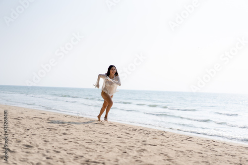Women exercising in the morning on the beach during the holidays make the body healthy.