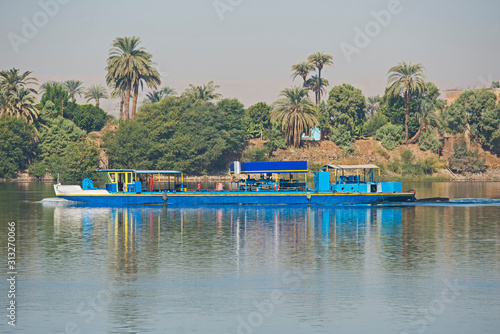 Old traditional river barge traveling through rural african landscape