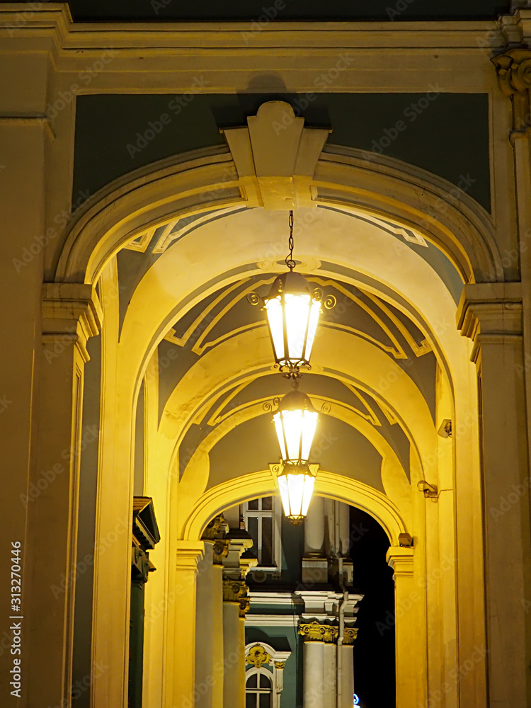 Naklejka premium cascade of several arches illuminated by yellow street lamps
