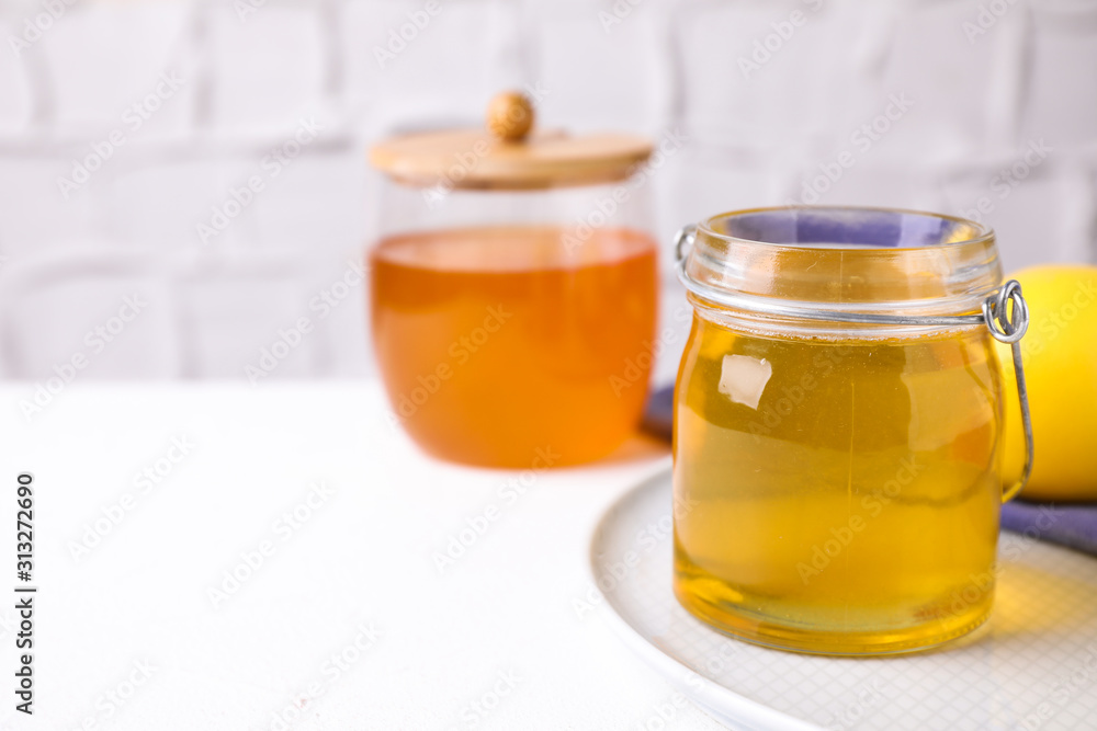 Tasty aromatic honey on white table, space for text