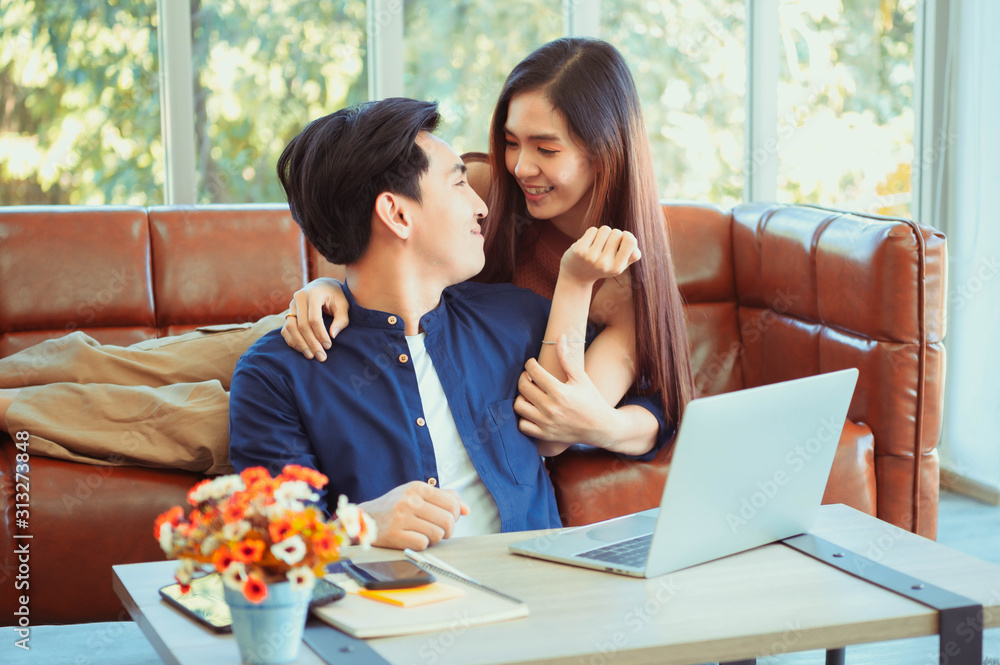 Portrait of a smiling young couple using laptop at home indoor. Attractive joyful woman showing something on its laptop computer to her boyfriend. Portrait of a smiling young couple using laptop at home indoor. Attractive joyful woman showing something on its laptop computer to her boyfriend.