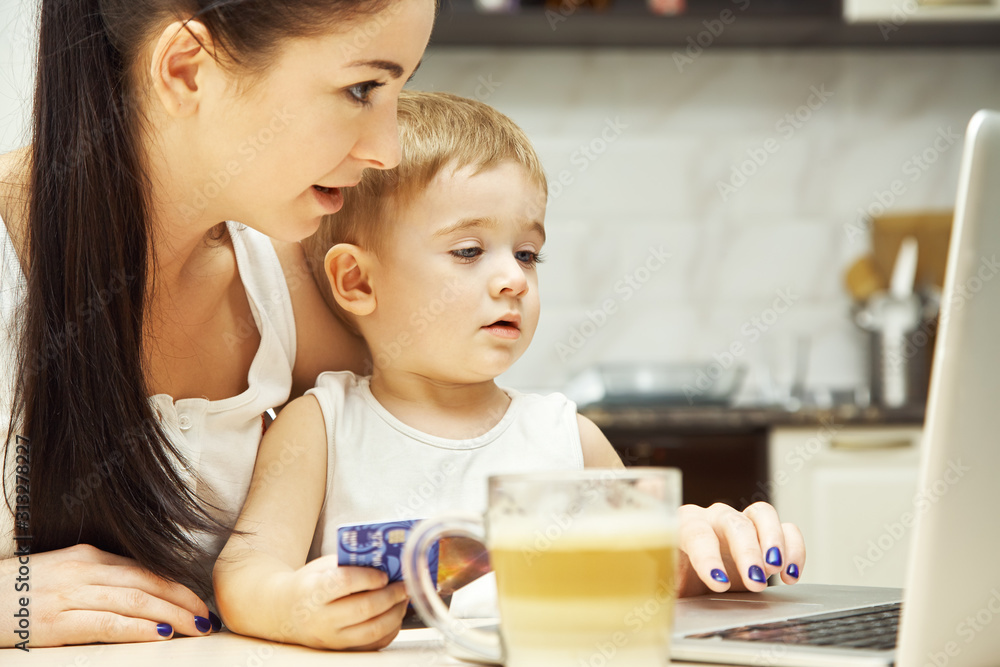 Mother with child works at the computer Mother with child works at the computer