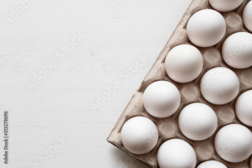 Foto Detail of white chicken eggs in paper tray.